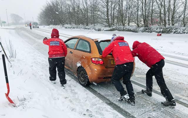 Members of the North Dartmoor Search and Rescue Team team assist a motorist (Martin Keene/PA)