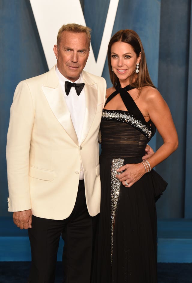 Kevin Costner and Christine Baumgartner standing next to each other at the Vanity Fair Oscar Party