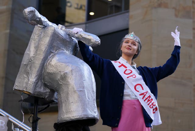 Climate activists stage a mock ceremony on the Buchanan Street Steps, featuring ‘the Queen’ turning off the oil tap (Andrew Milligan/PA)