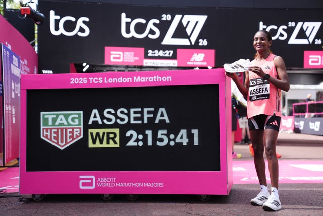 Tigst Assefa standing next to her London Marathon time