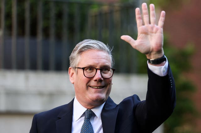 Sir Keir Starmer smiling while waving