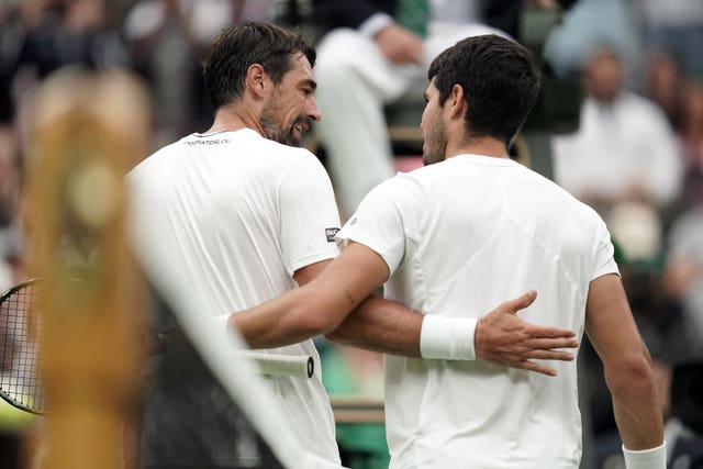 Carlos Alcaraz and Jeremy Chardy (left) embrace at the net after their match 