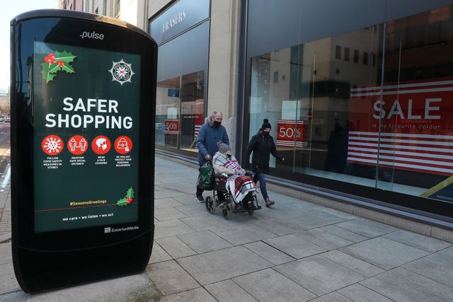People walk past advertising in Belfast city centre during a six-week lockdown in 2020