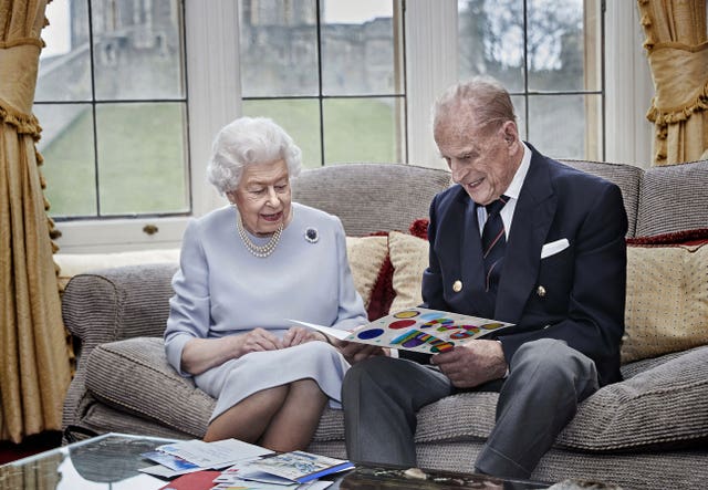 The Queen and Philip look at an anniversary card made by the Cambridge children