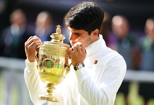 Carlos Alcaraz celebrates with the Wimbledon trophy