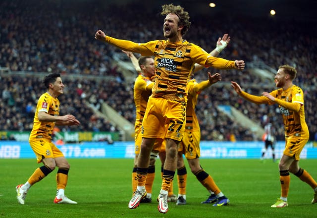 Cambridge United’s Joe Ironside (hidden) celebrates scoring their side’s first goal of the game with Ben Wormann and team-mates during the Emirates FA Cup third round match at St. James’ Park, Newcastle upon Tyne. Picture date: Saturday January 8, 2022.