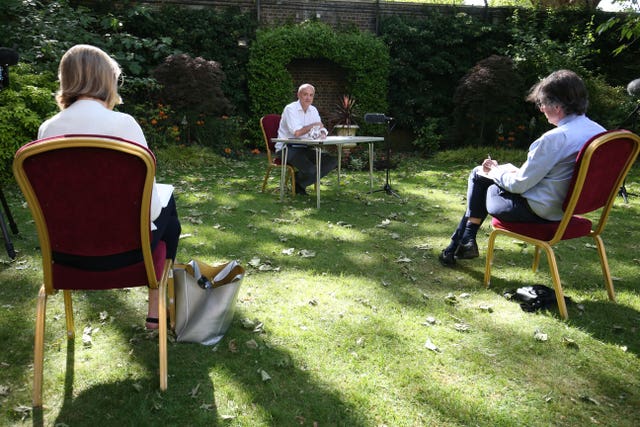 Journalists sit at a distance while listening to Dominic Cummings, senior aide to Prime Minister Boris Johnson, make a statement in the Downing Street rose garden in May about his trip to Durham during lockdown restrictions