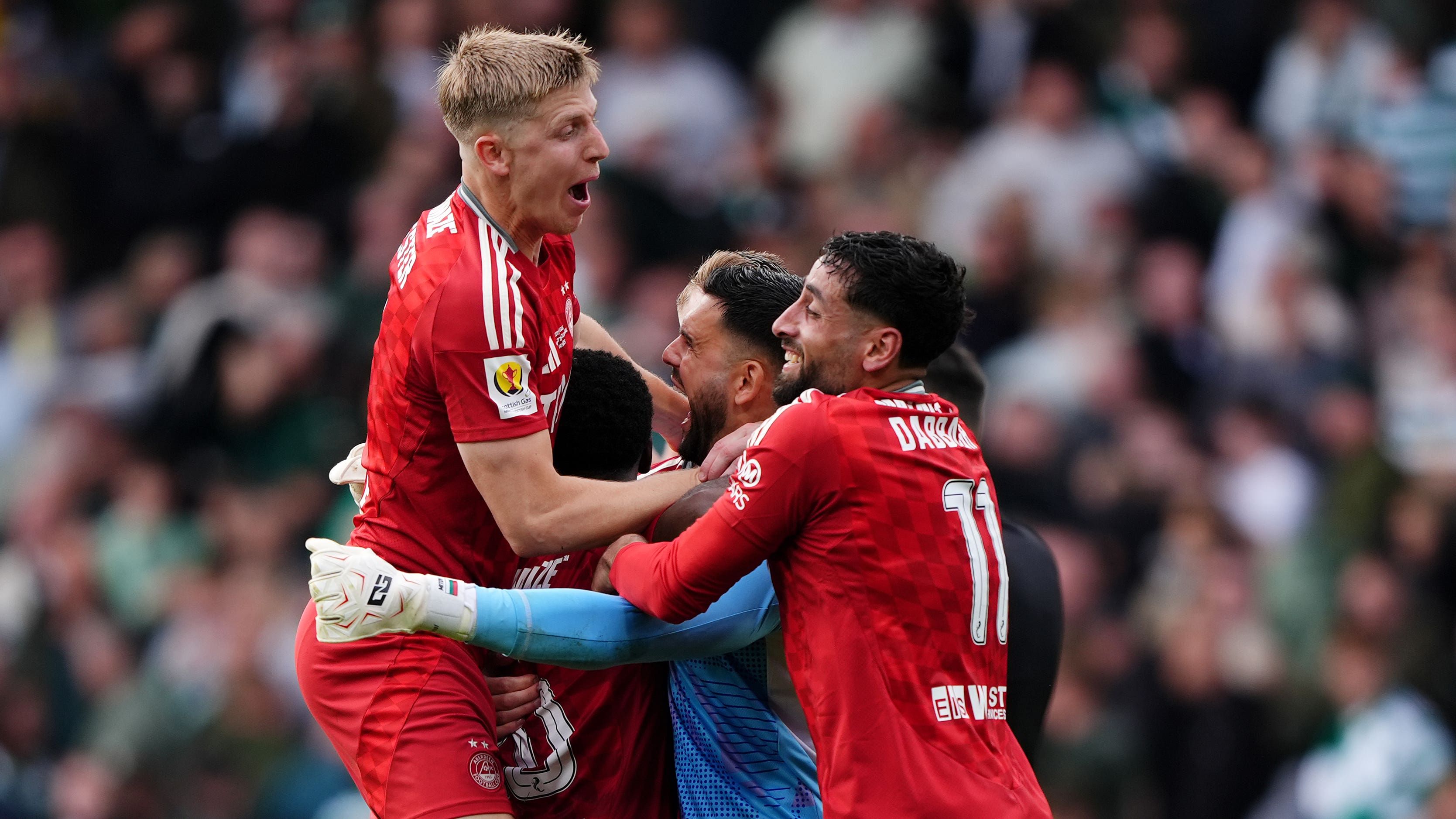 Aberdeen players mob goalkeeper Dimitar Mitov (Andrew Milligan/PA)