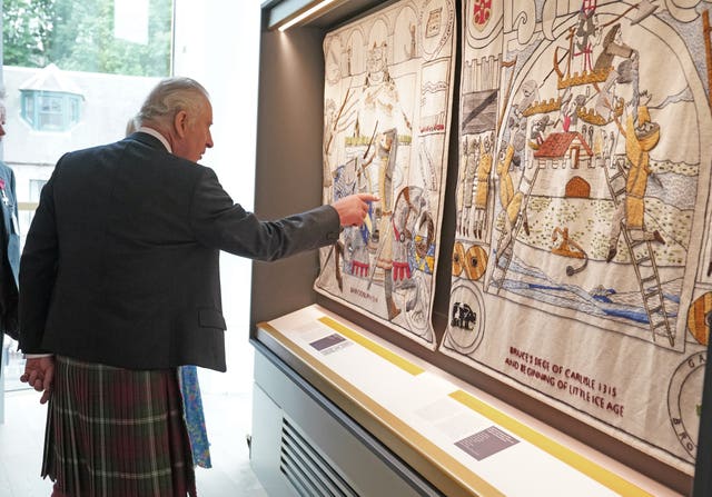 The King pointing at a panel of The Great Tapestry of Scotland