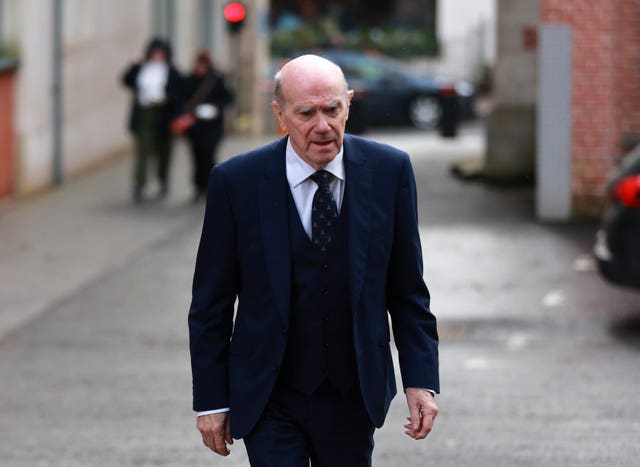 Sir Ronnie Flanagan walks down a street
