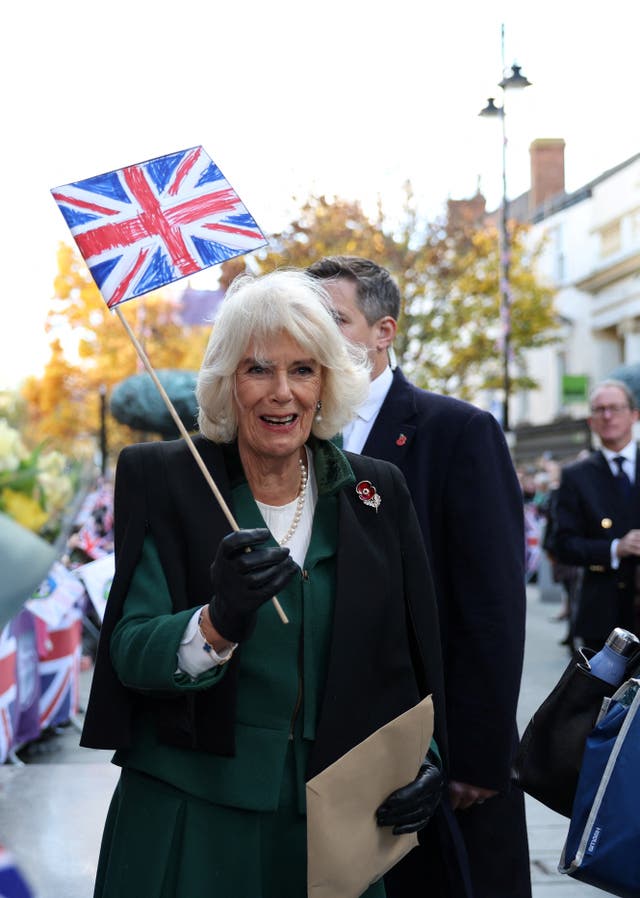 Camilla holds a Union flag as she arrives at Mansion House