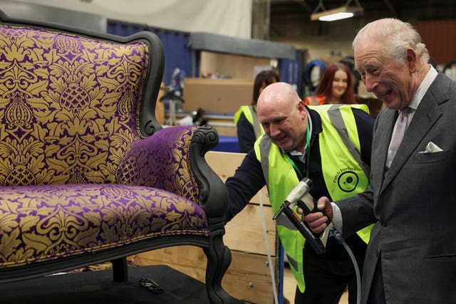 The King uses a stapler to help restore a chair