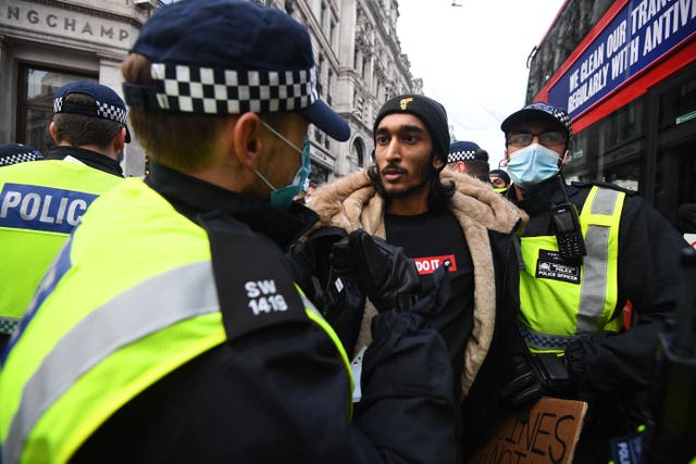A man is detained during an anti-lockdown protest at Oxford Circus 