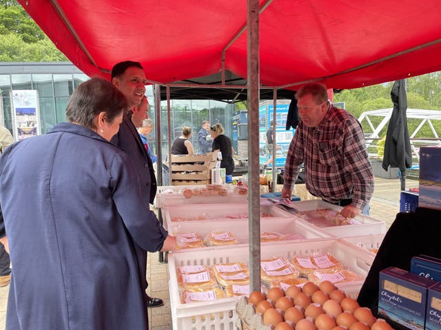 Scottish Labour leader Anas Sarwar with deputy leader Jackie Baillie look at a stall of food at a market under a red canopy