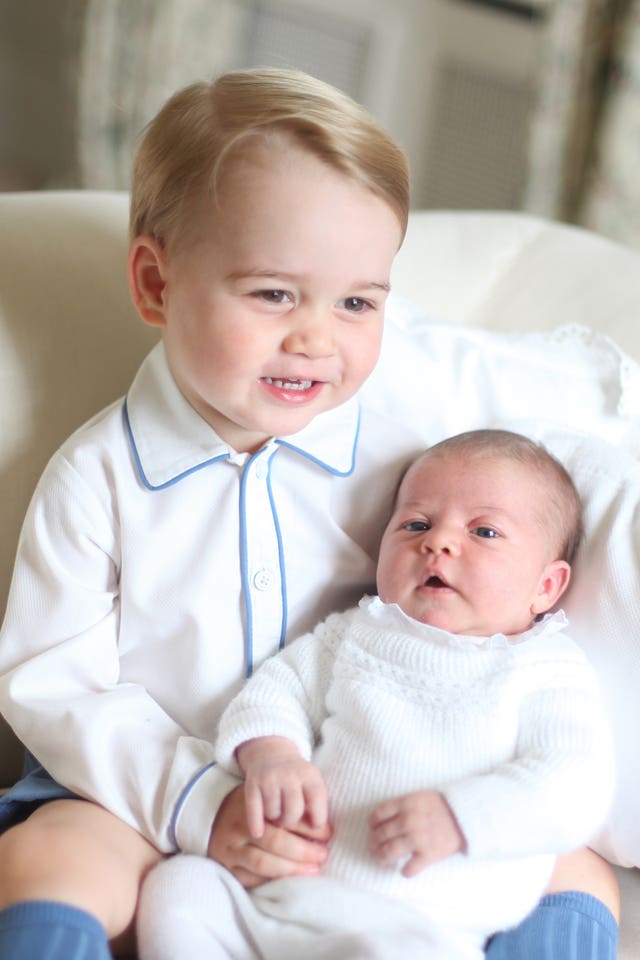 Prince George holding two-week-old Princess Charlotte (Duchess of Cambridge/PA)