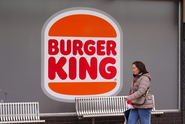 A woman walks past a Burger King store