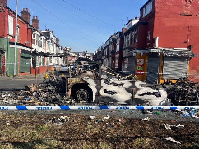 A burnt-out car in the Leeds suburb of Harehills