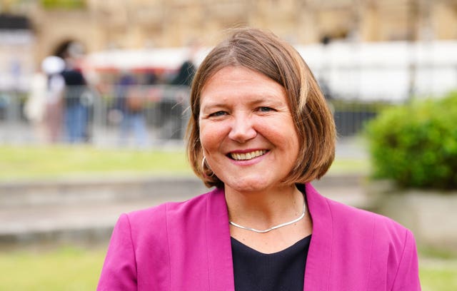 Headshot of Ellie Chowns wearing pink blazer and black top, smiling