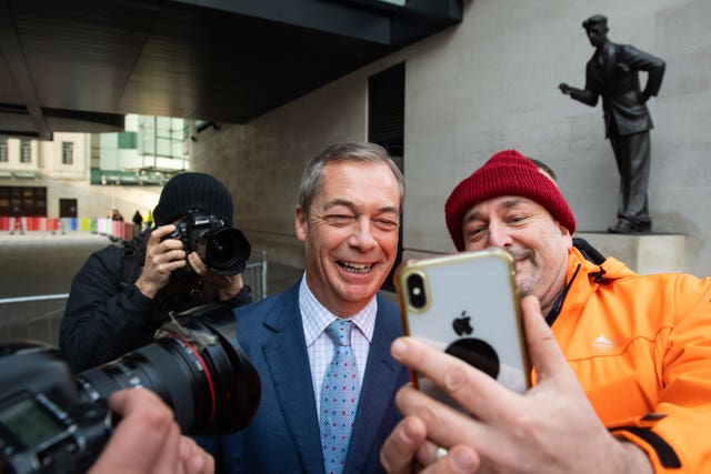 Nigel Farage poses for a selfie with a member of the public