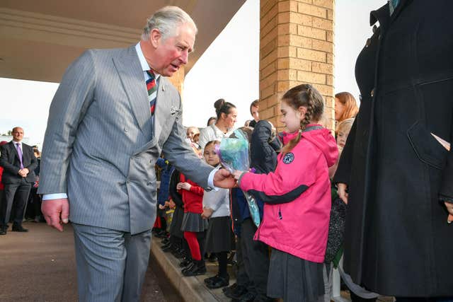 Bella Armstrong, 6, from Innsworth, offers the Prince of Wales flowers (Ben Birchall/PA)