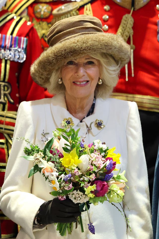 Queen Camilla holds the Nosegay bouquet as she poses with Yeomen of the Guard and religious representatives as she attends the Royal Maundy service at Worcester Cathedral 