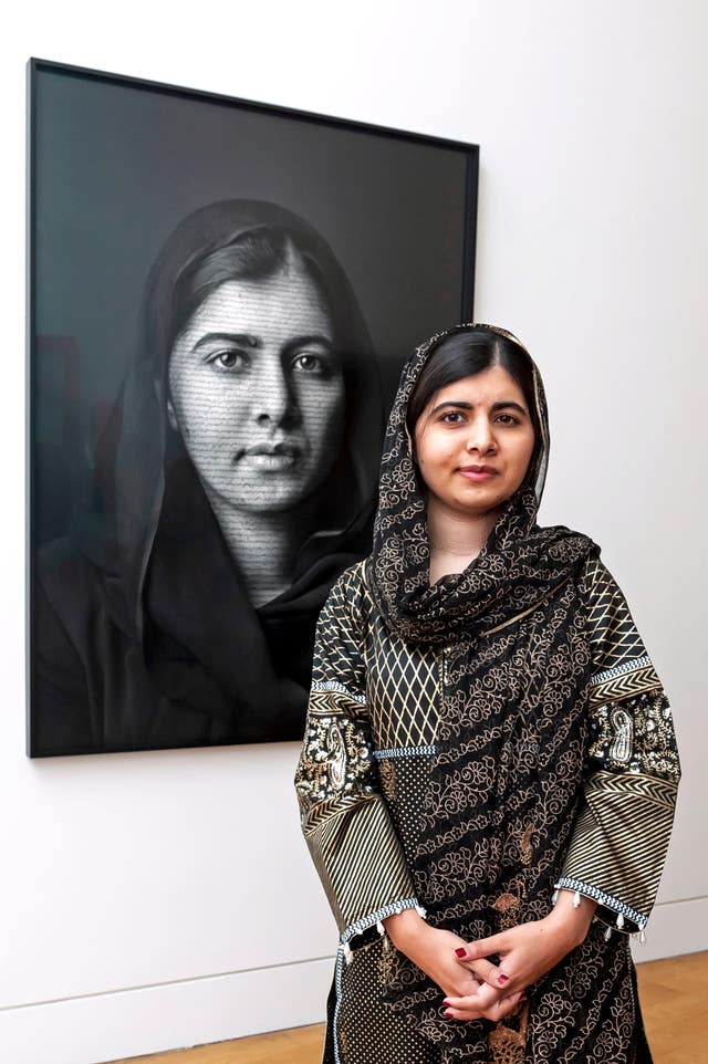 Girls’ education activist Malala Yousafzai with her portrait at the National Portrait Gallery