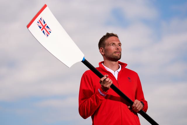 Tom Ford holds a paddle with the Union Jack on it. 