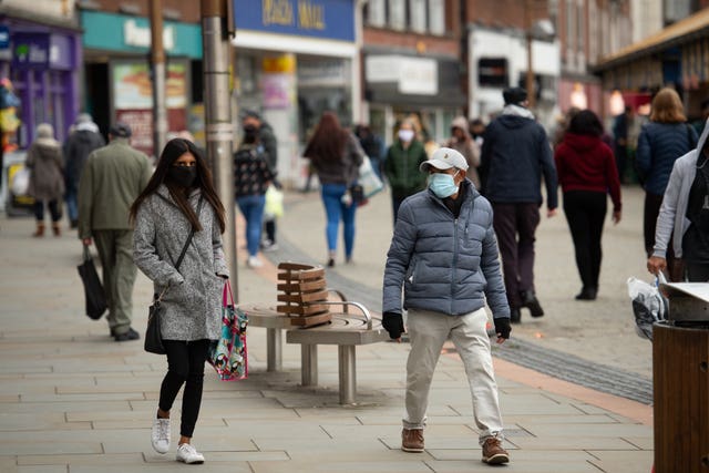 Shoppers wearing protective face masks walk along Market Place, Dudley, in the West Midlands (Jacob King/PA)