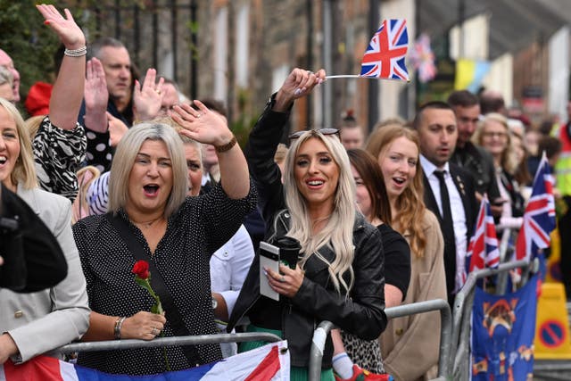 Members of the public gather outside Hillsborough Castle ahead of the royal visit