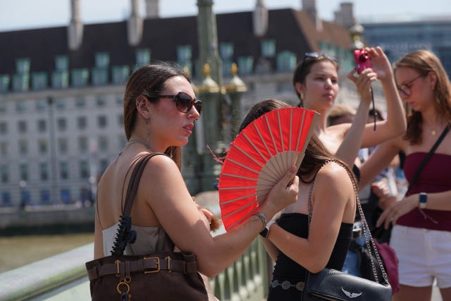 A woman using a fan on Westminster Bridge