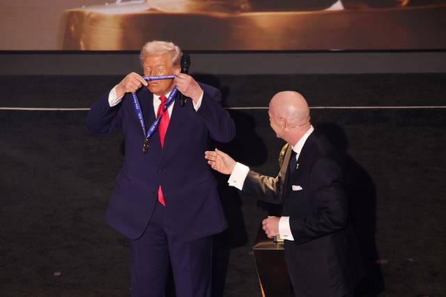 Donald Trump puts on a medal for winning the FIFA peace prize
