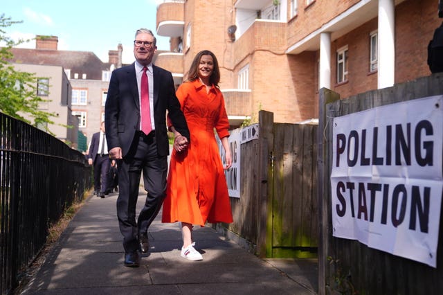Sir Keir Starmer and his wife Victoria walk hand-in-hand towards a polling station