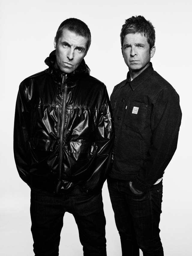 Black and white picture of Liam Gallagher (left) and his brother Noel wearing black jeans and jackets