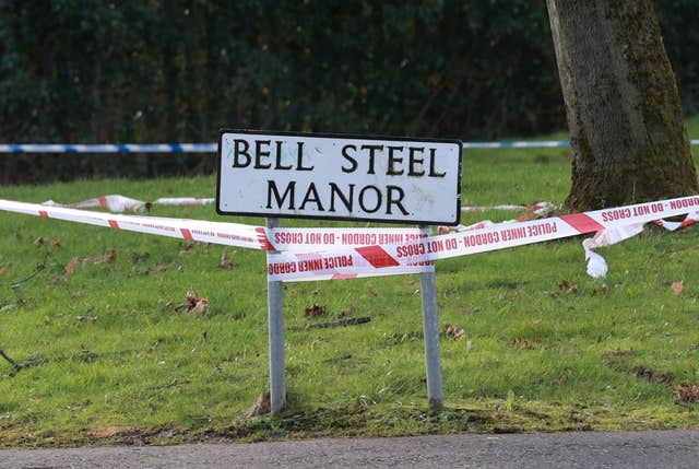 A road sign for Bell Steel Manor with 'do not cross' tape attached