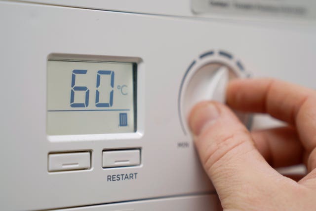 A homeowner turning down the flow temperature of a gas boiler