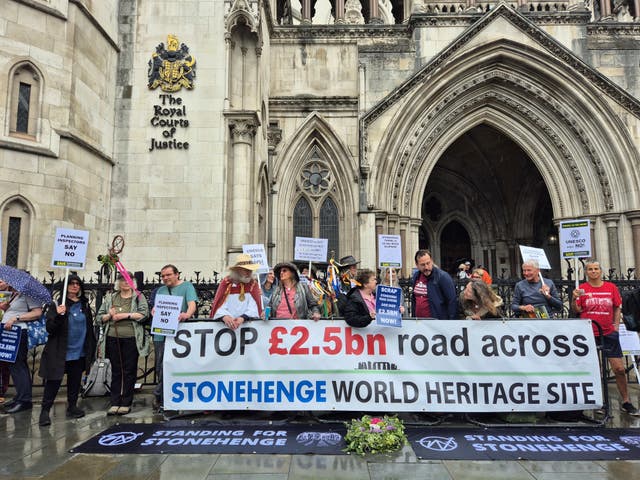 Protesters outside the Royal Courts of Justice in London holding a banner which reads "Stop £2.5bn road across Stonehenge World Heritage Site"