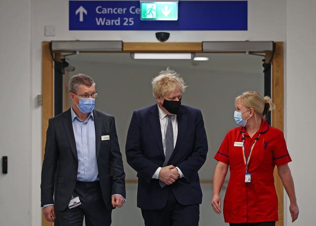 Prime Minister Boris Johnson walks with Chief Executive Professor Joe Harrison (left) and Divisional Chief Nurse Emma Codrington during a visit to Milton Keynes University Hospital in Buckinghamshire