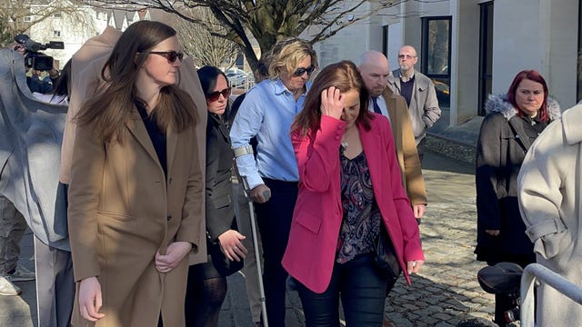 Nerys Lloyd leaving court as people attempt to use coats to shield her from view