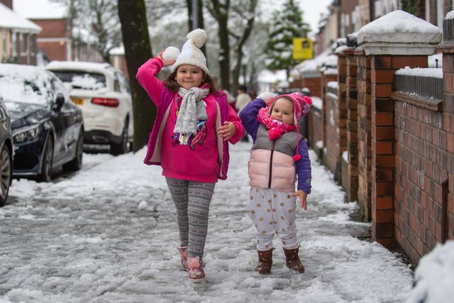 Sisters play with snowballs