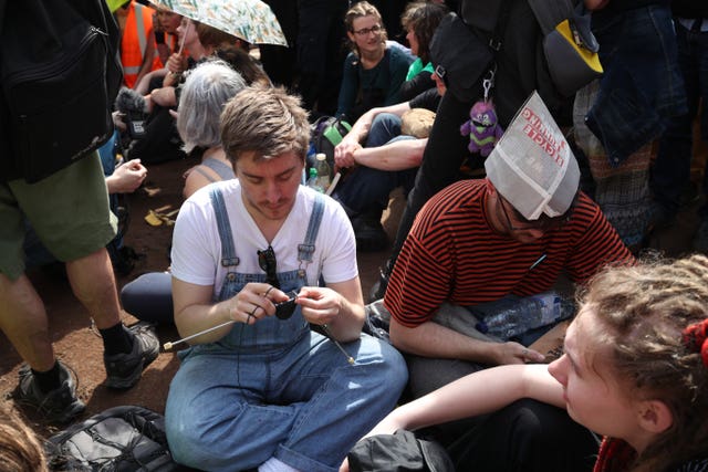 A climate activist knits during an Extinction Rebellion demonstration at Oxford Circus