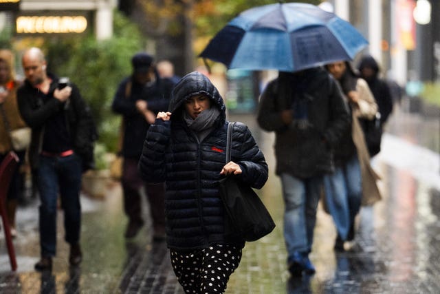 People using umbrellas while walking in heavy rain