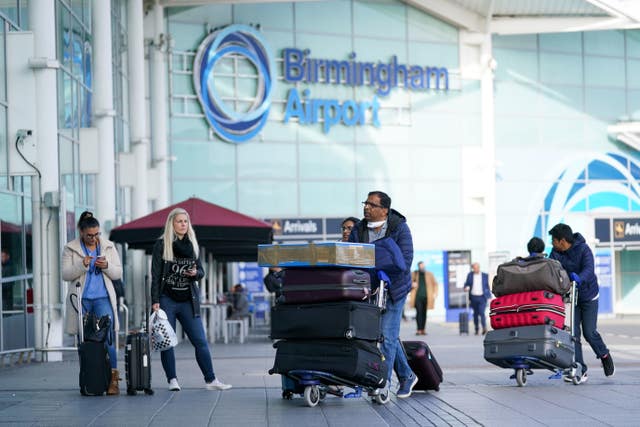 People pushing luggage trolleys at Birmingham Airport