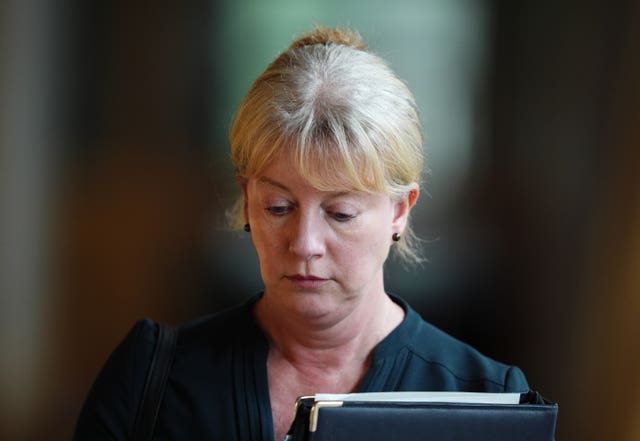 Shona Robison looks down as she walks through a corridor inside the Scottish Parliament