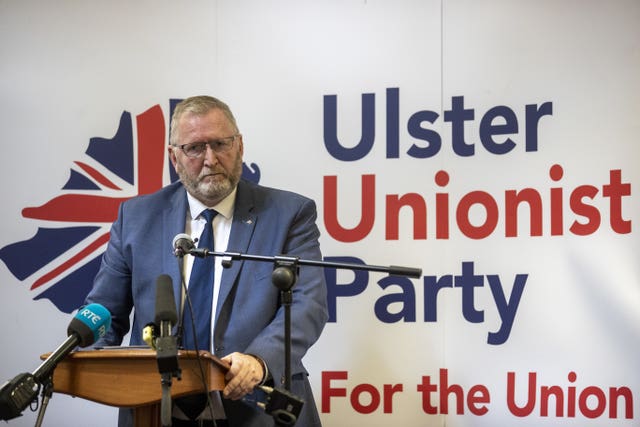 A man stands in front of a sign reading Ulster Unionist Party