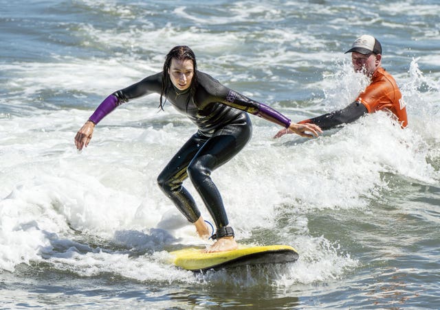 A surfer enjoys the warm weather on Scarborough beach, North Yorkshire 