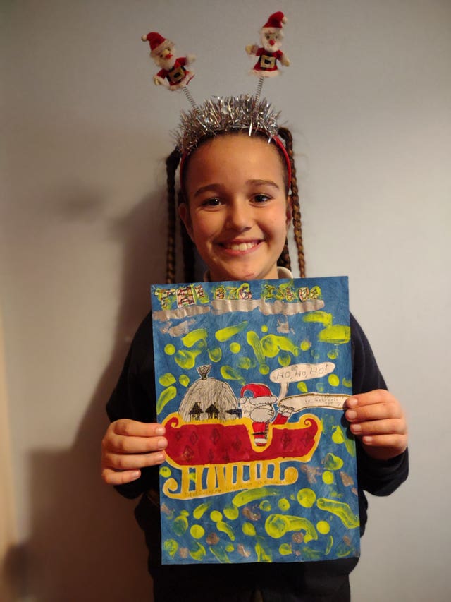 Seven-year-old Gabriela Beard, from Worcester, holding a picture she drew of Father Christmas delivering presents to homeless people which will appear on the front cover of this week’s Big Issue magazine
