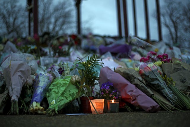 Floral tributes and a candle left at the Bandstand on Clapham Common, London (Steve Parsons/PA)