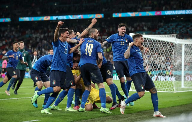 Italy players celebrate winning the penalty shootout 