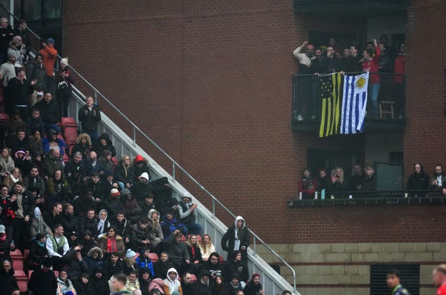 Fans celebrate as they watch from a nearby building 