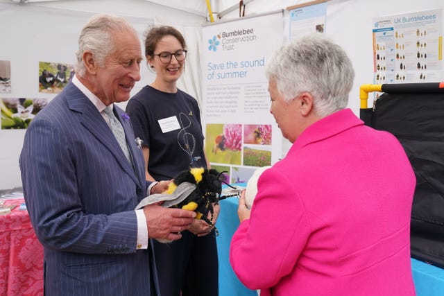 The King is presented with a stuffed toy bumblebee by Gill Perkins (right) CEO of the Bumblebee Conservation Trust and Rosalind Shaw (centre) Project Officer at the Bumblebee Conservation Trust, during a reception at Clarence House, London, to celebrate four decades of the Prince of Wales’s Charitable Fund